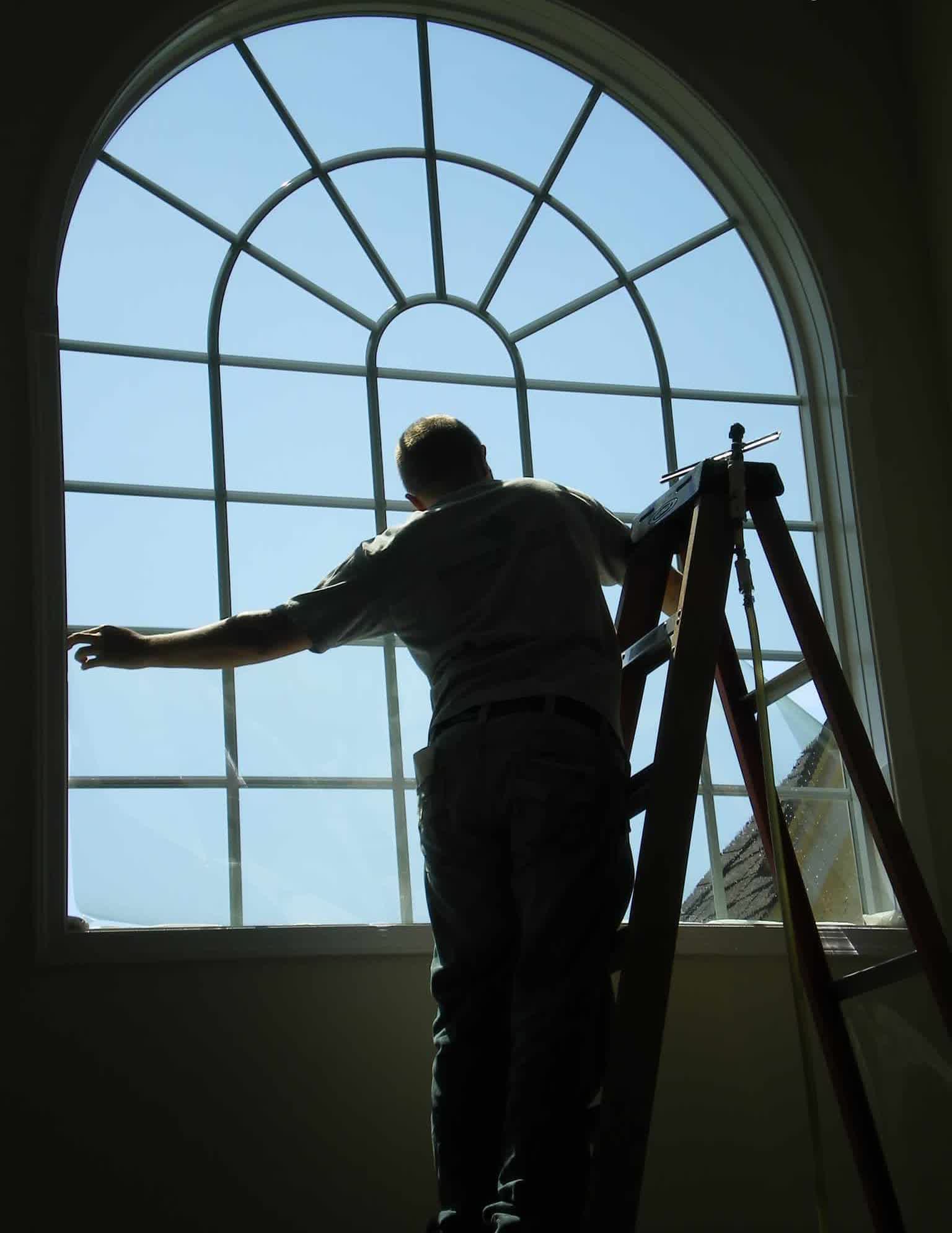 Luxury home with arched windows being installed
